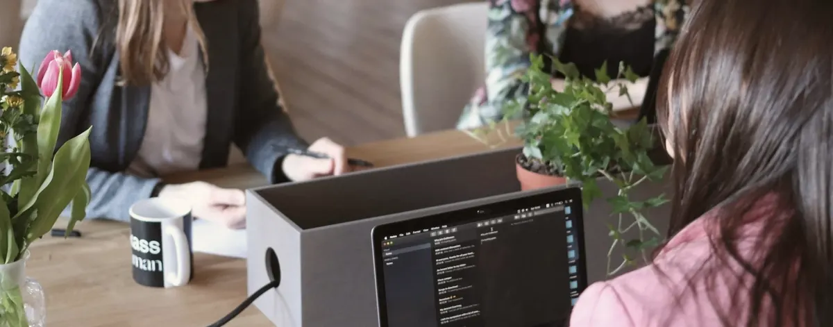 Colleagues working together with a laptop and coffee mugs