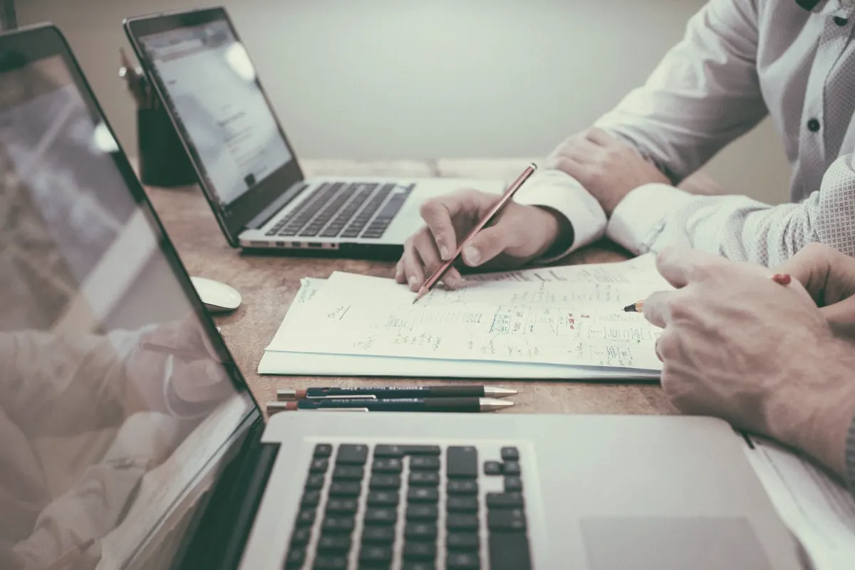 A laptop and handwritten notes on a desk